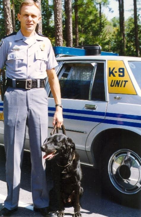 Trooper Russell Wilson and K-9 Pinch in front of Highway Patrol car