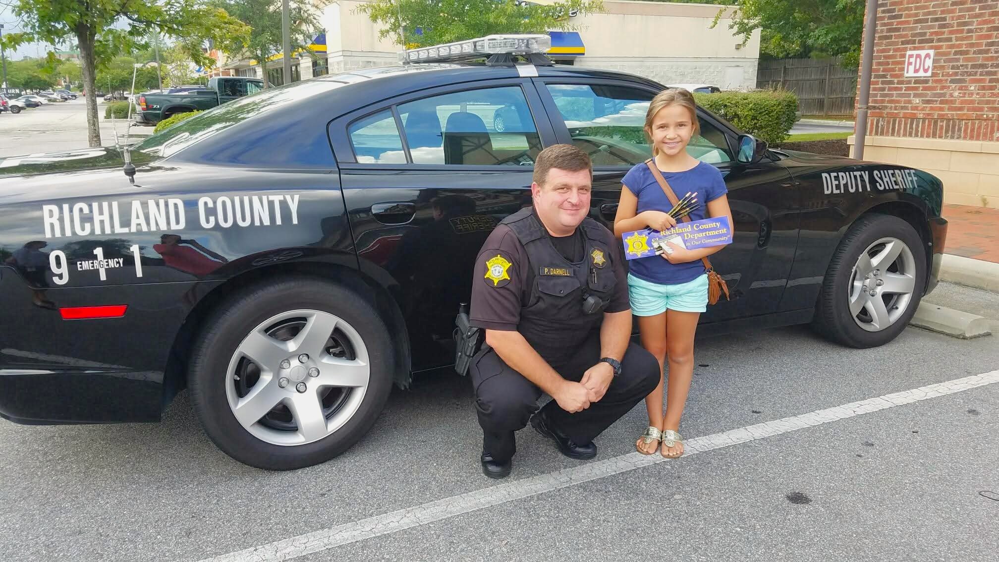 Darnell with child in front of police car